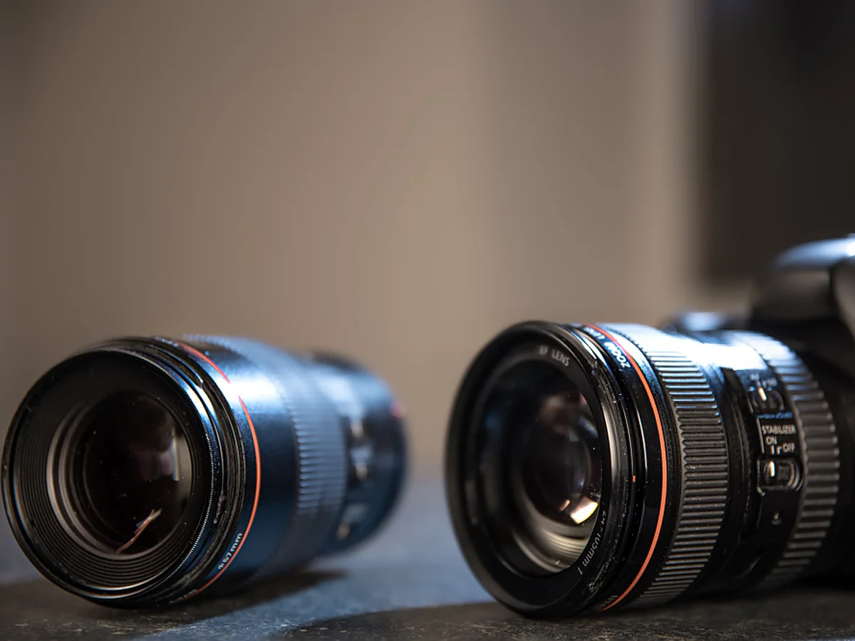 Two camera lenses beside a camera body