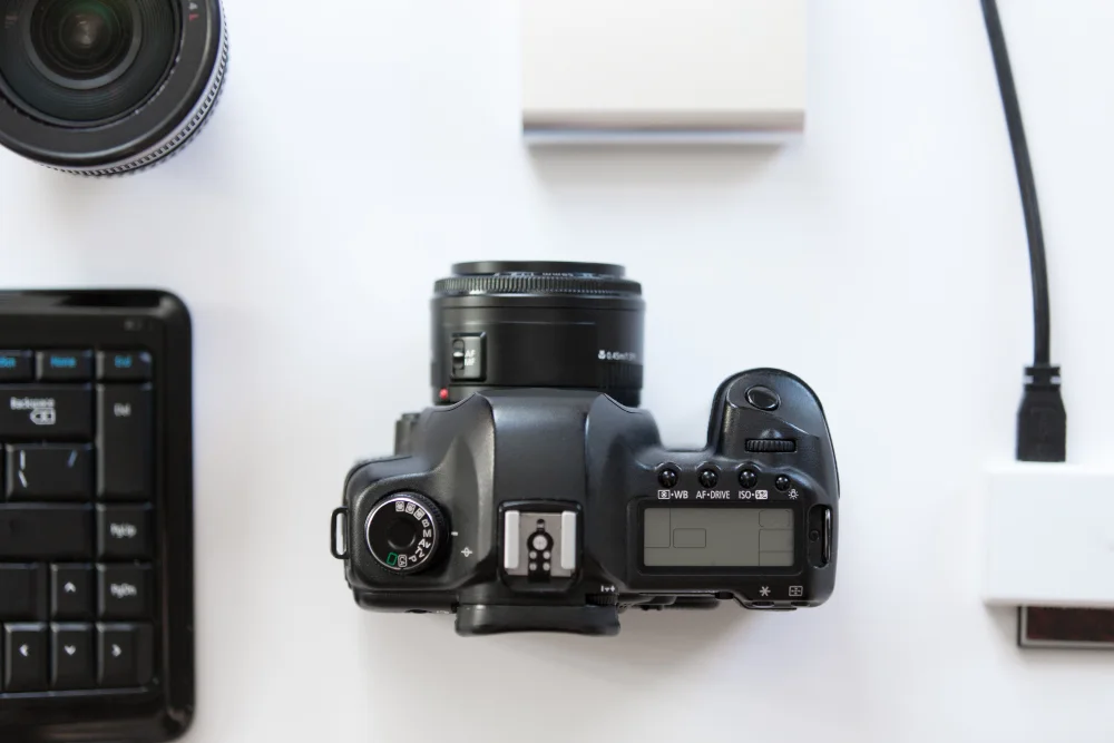 Camera seen from above on a white desk with accessories