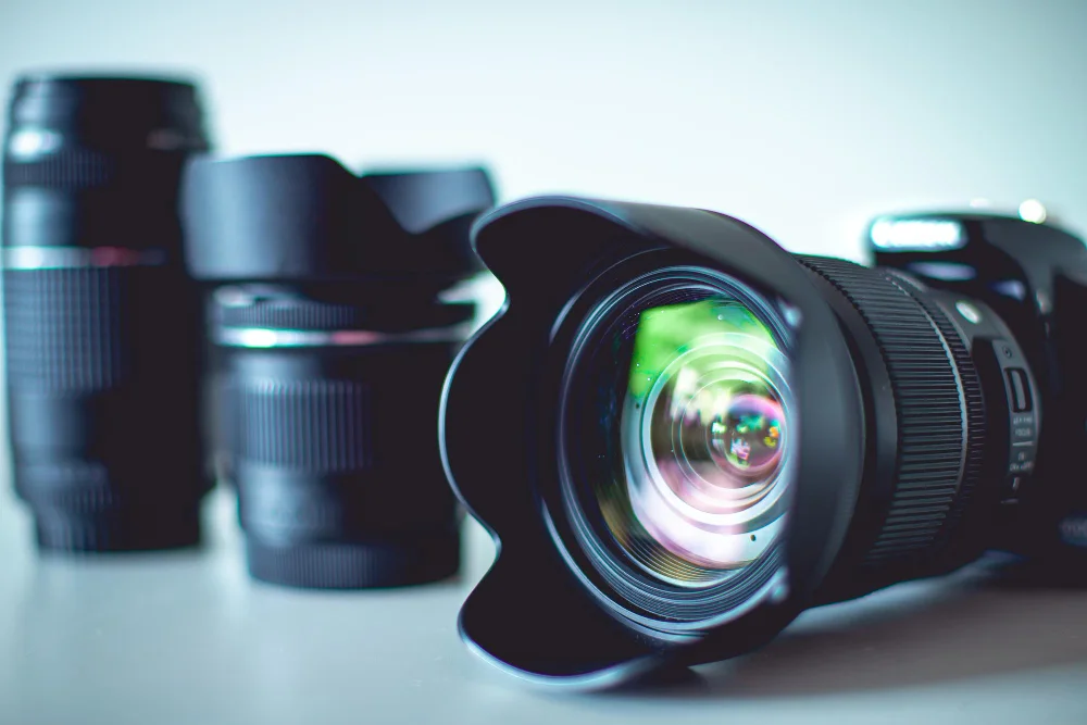 Camera with lens hood in front of two lenses